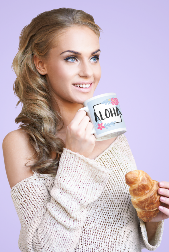 beautiful woman eating a croissant holding a coffee mug that says ALOHA